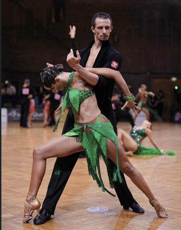 A dance couple in a green Latin competition outfit