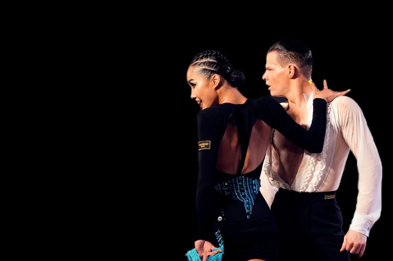 A dance couple in dramatic black and white competition outfits