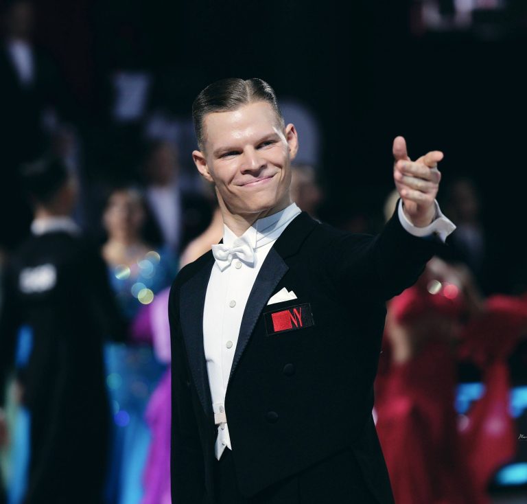 Dancer in a tailcoat smiling during a performance
